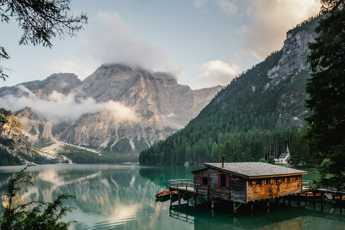 Alpine lake reflecting mountains beneath a cloudy sky